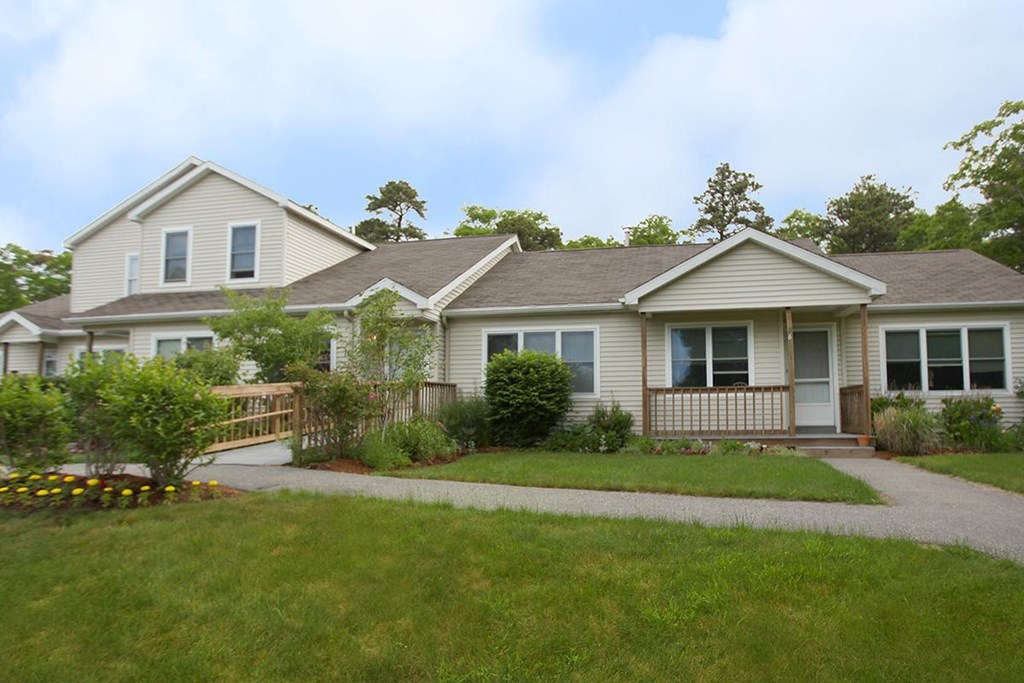 the front of a house with a yard and a sidewalk
