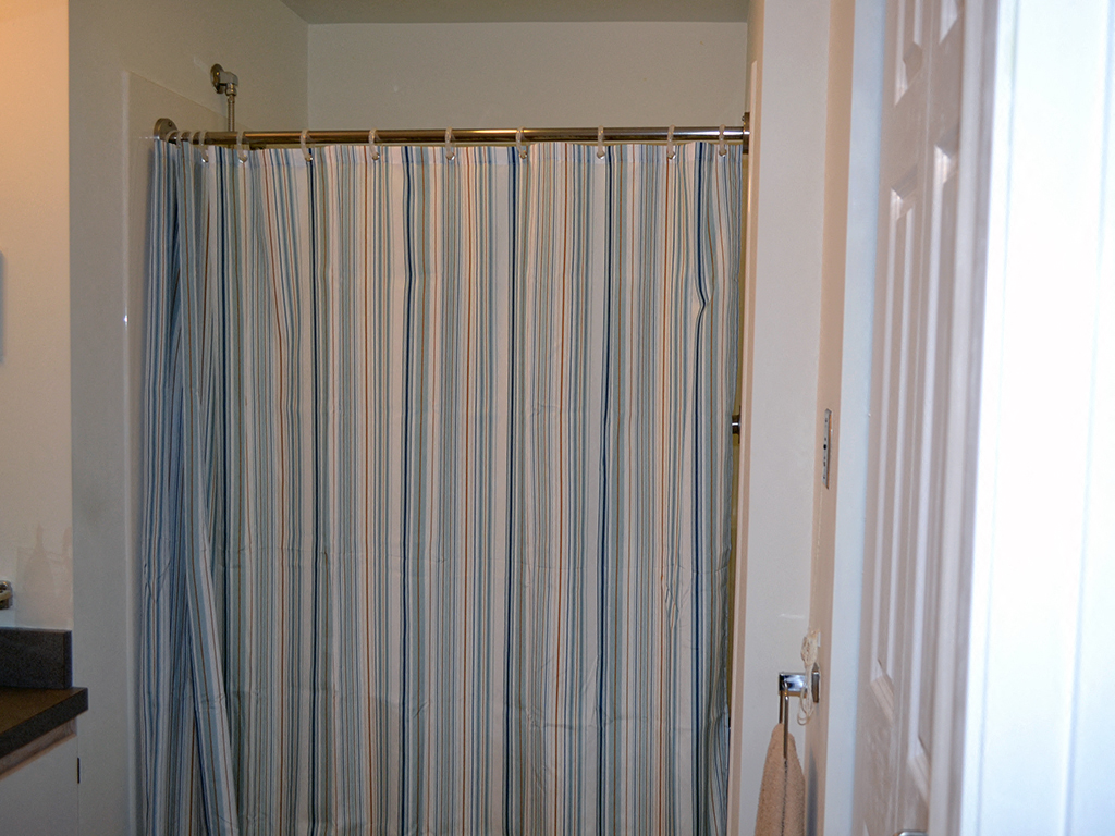 a striped shower curtain in a bathroom