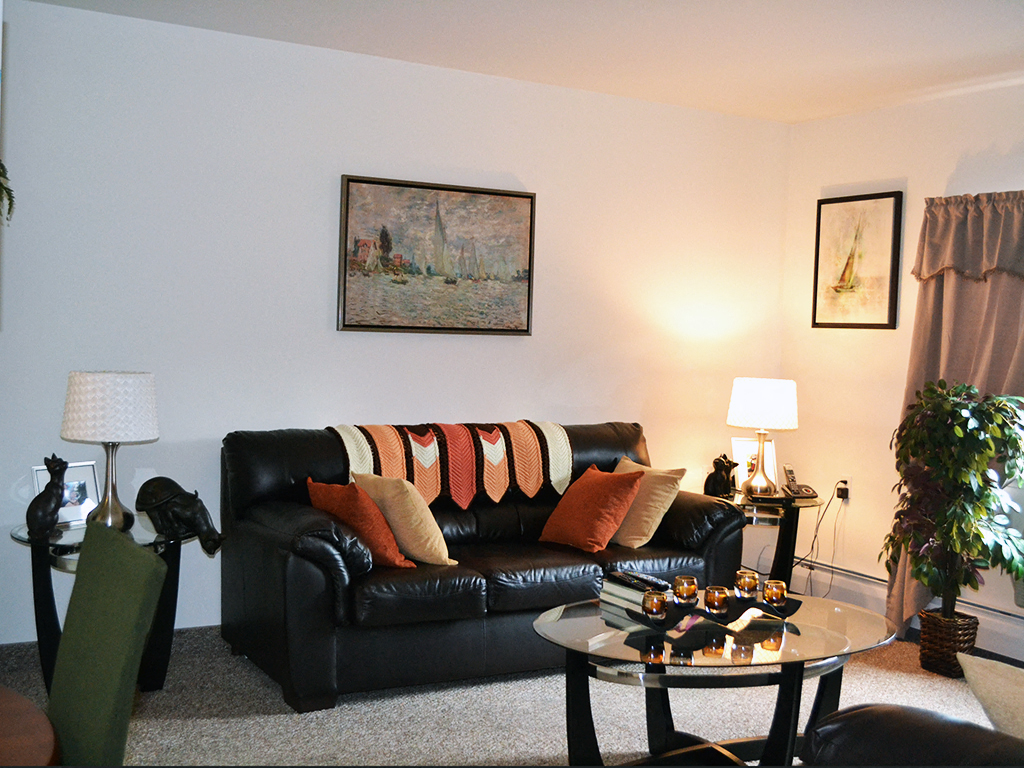 a living room with a black leather couch and a coffee table