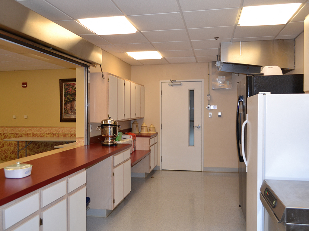 a kitchen with a counter and a refrigerator and a door