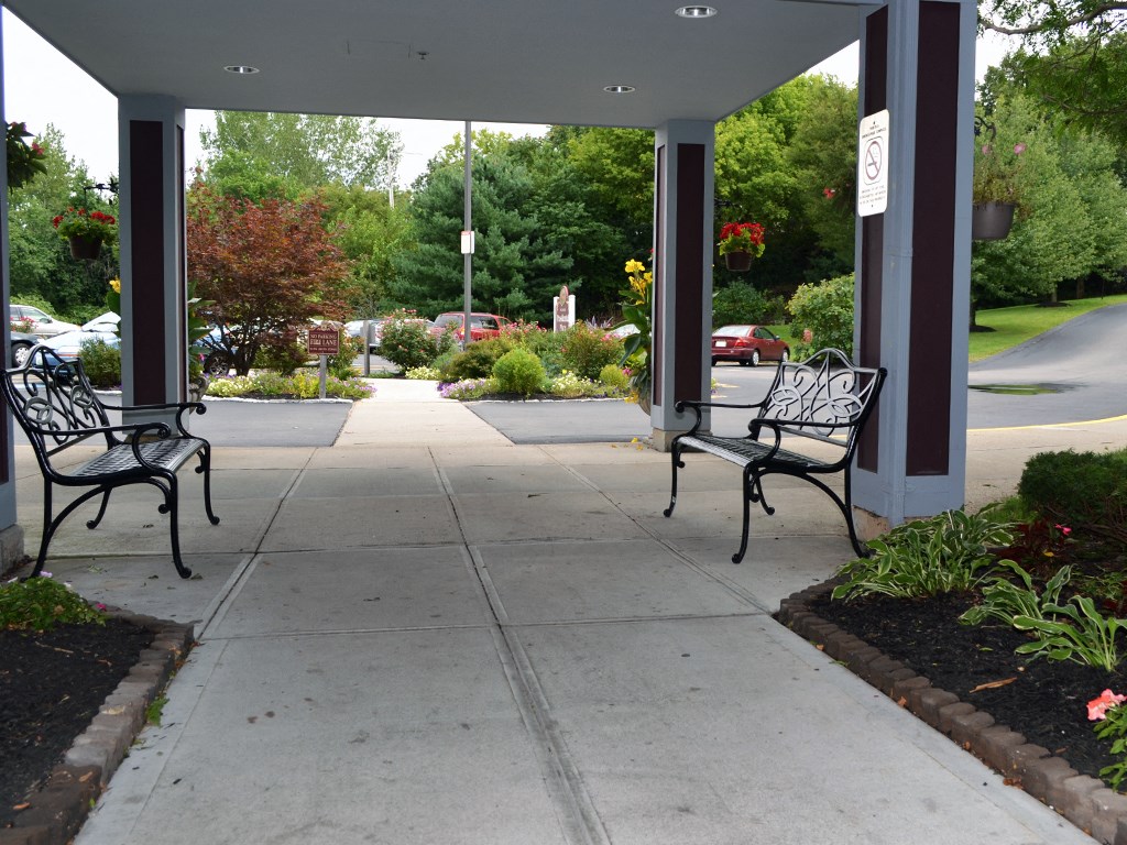 two benches sitting under a covered area on a sidewalk