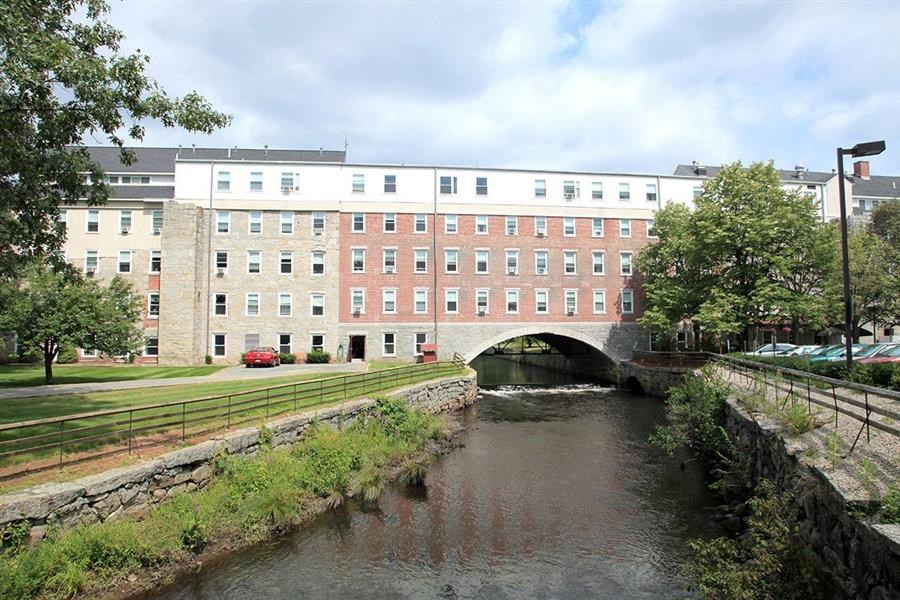 a river running under a bridge in front of a building