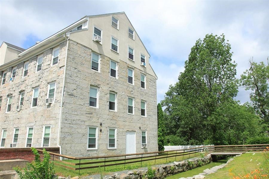 an old stone building with a wooden fence