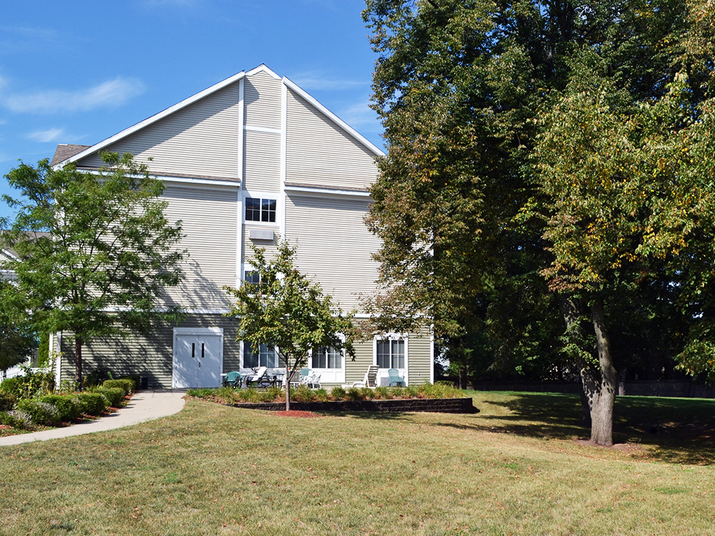 a white house with a yard and trees in front of it