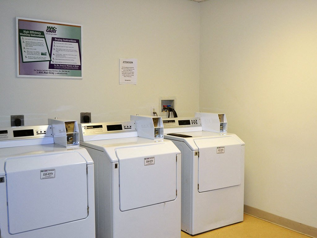 four washers and dryers in a laundry room