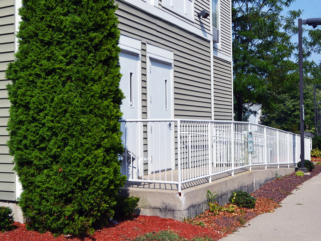 a porch with a white railing in front of a house