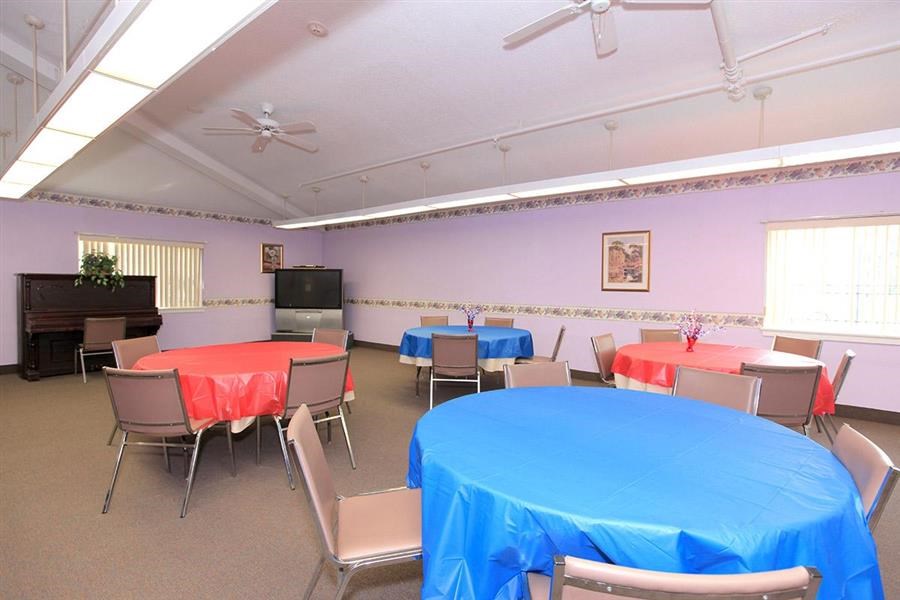 a room with tables and chairs and a television