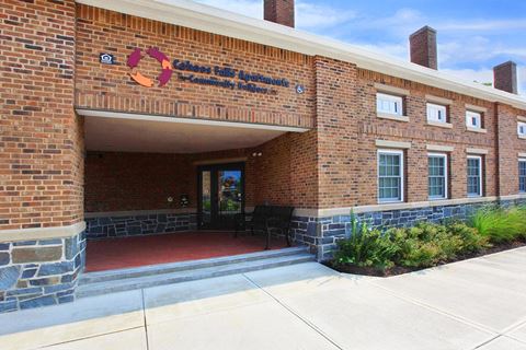 the front of a brick building with a red walkway