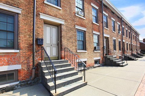 a brick building with stairs and a white door