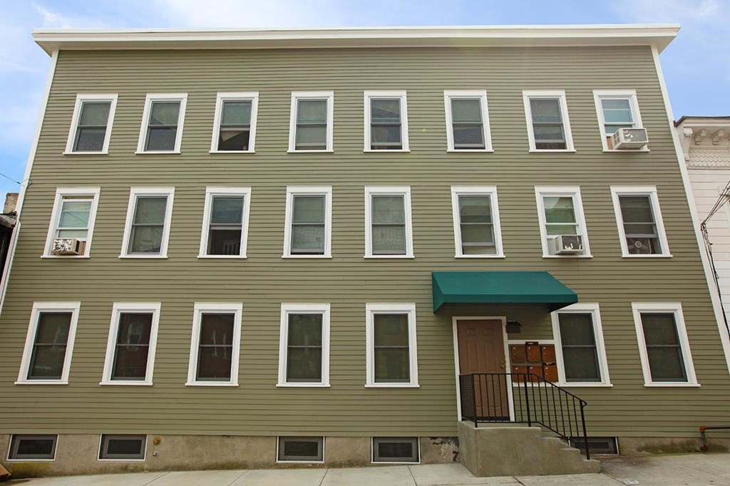a large apartment building with many windows and a green roof