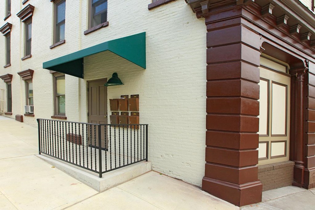 a white brick building with a green triangle above the door