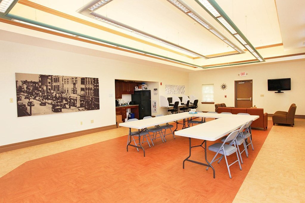 a large room with tables and chairs and a living room