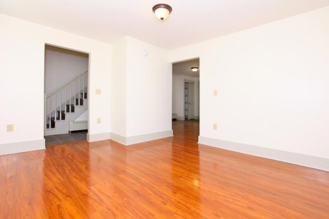 an empty living room with a hard wood floor and a staircase