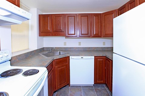 a kitchen with white appliances and wooden cabinets