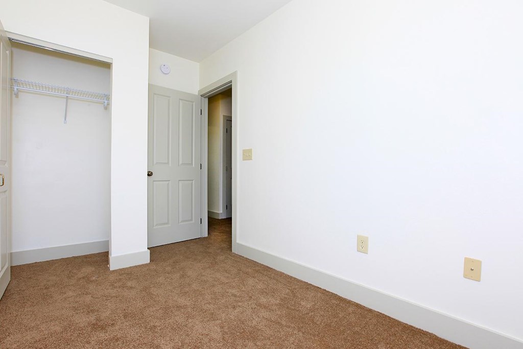 a bedroom with a closet and a door to a bathroom
