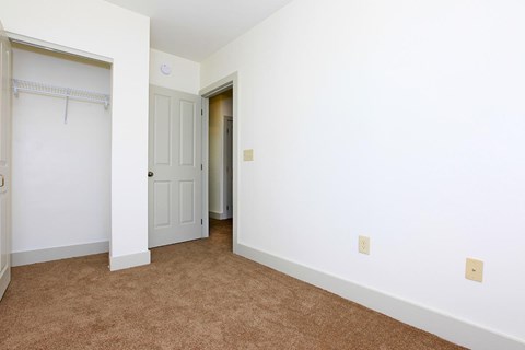 a bedroom with a closet and a door to a bathroom