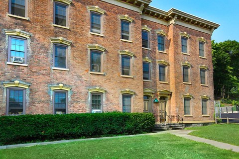 a red brick building with a lawn in front of it