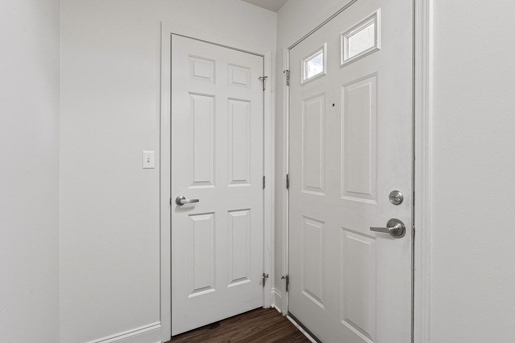 a bedroom with two doors and a hardwood floor