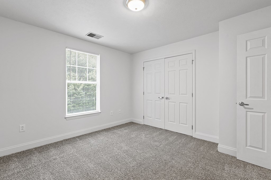 a bedroom with two doors and a carpeted floor