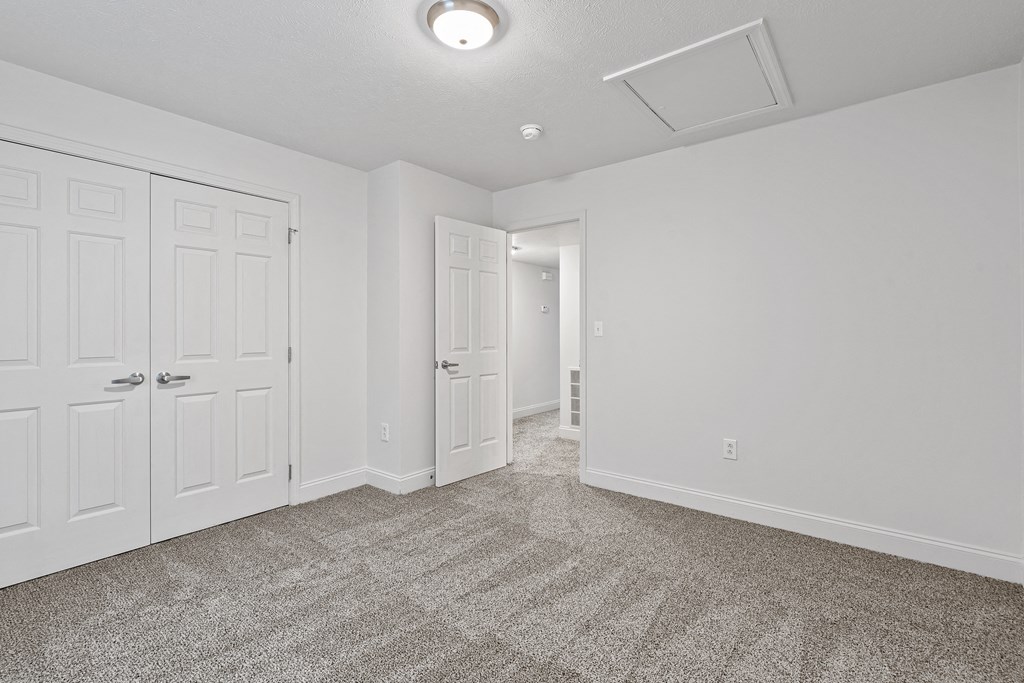a bedroom with two doors and a carpeted floor