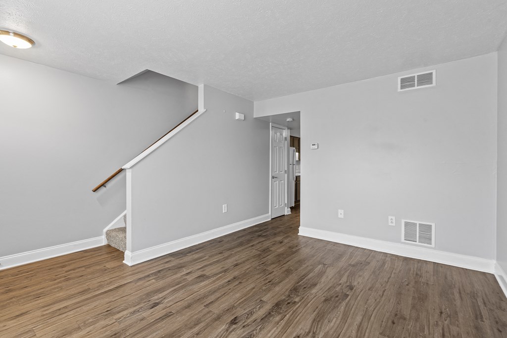 a living room with hardwood floors and grey walls