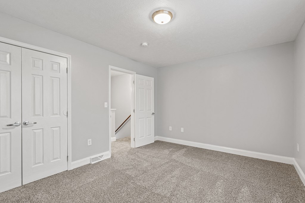 a bedroom with two doors and a carpeted floor