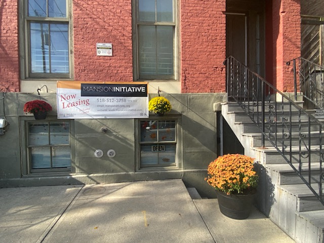 the front of a building with a sign on the side of it