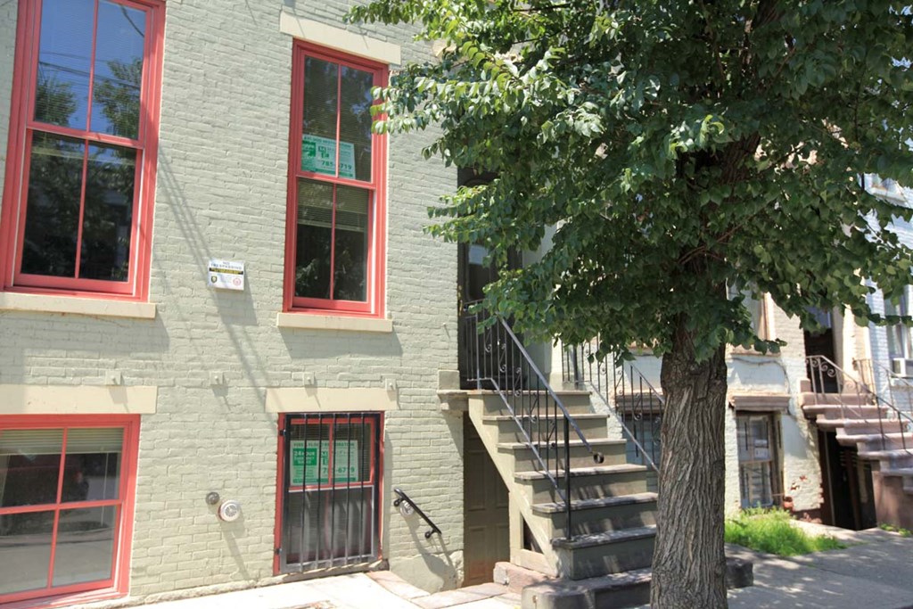 a building with stairs and a tree in front of it