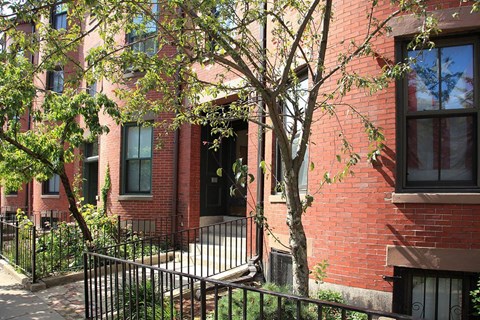 a red brick building with a tree in front of it