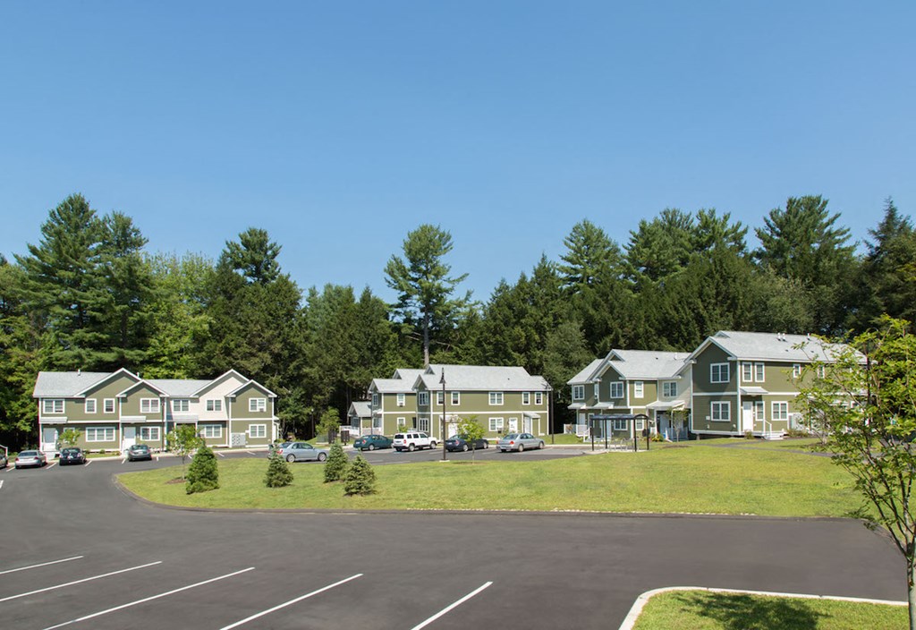 a row of houses with a parking lot and trees