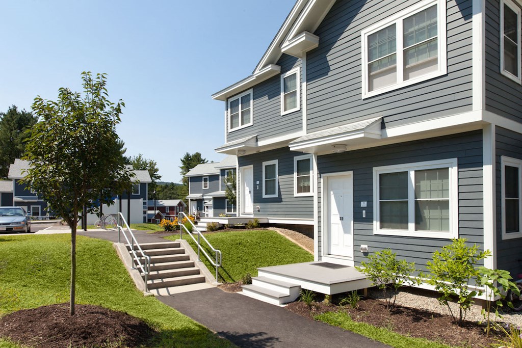 a row of houses with stairs and a sidewalk
