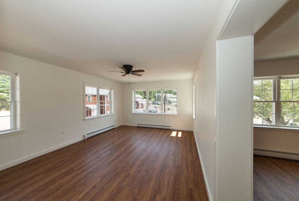 a living room with wood floors and a ceiling fan