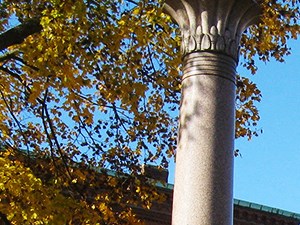 a monument in the middle of a park in front of a building
