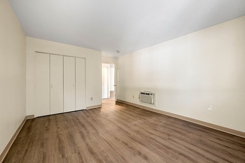 a living room with white walls and wooden floors and a fireplace