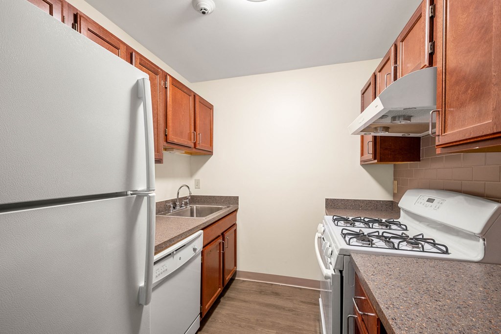 a kitchen with white appliances and wood cabinets
