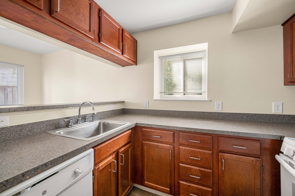 a kitchen with granite counter tops and wooden cabinets