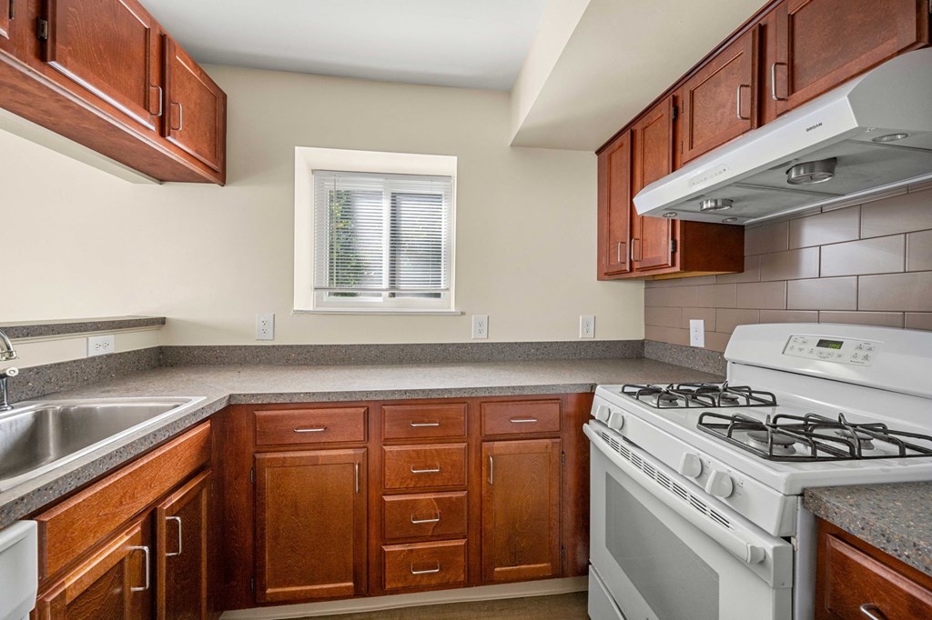 full kitchen with white appliances and wooden cabinets and granite counter tops