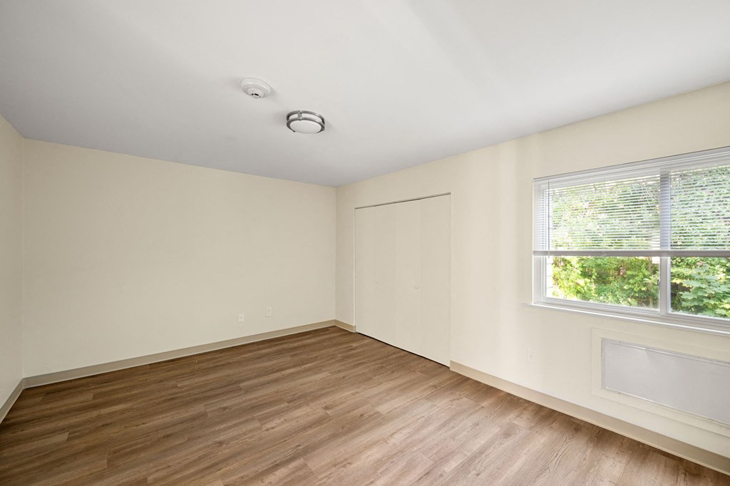 an empty room with wood floors and a window