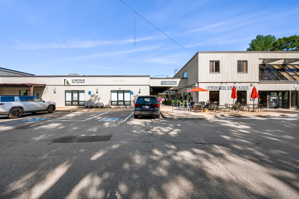 an empty parking lot in front of a building with a car parked