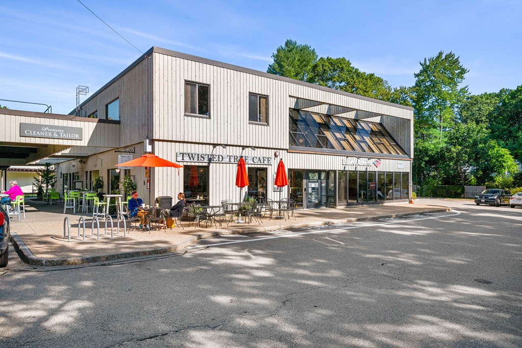 a building with tables and chairs outside of it on a street