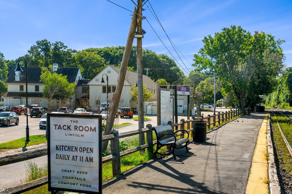 a sidewalk with a sign for the kick room and a bench