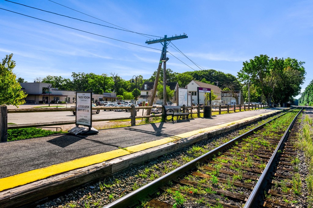 a train station with train tracks and a yellow platform