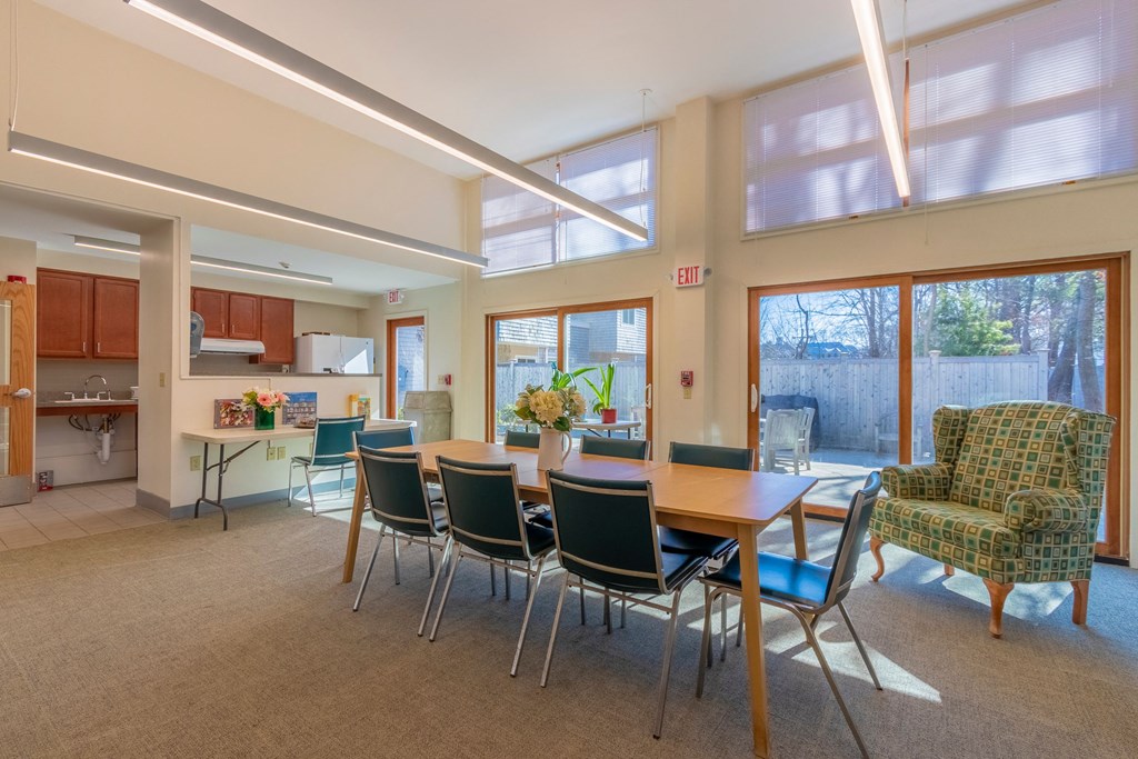 a dining room with a table and chairs and a kitchen with large windows