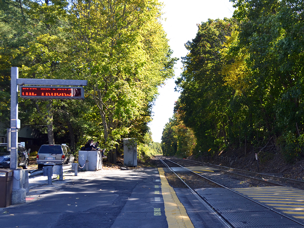 a train station with a red sign on the tracks