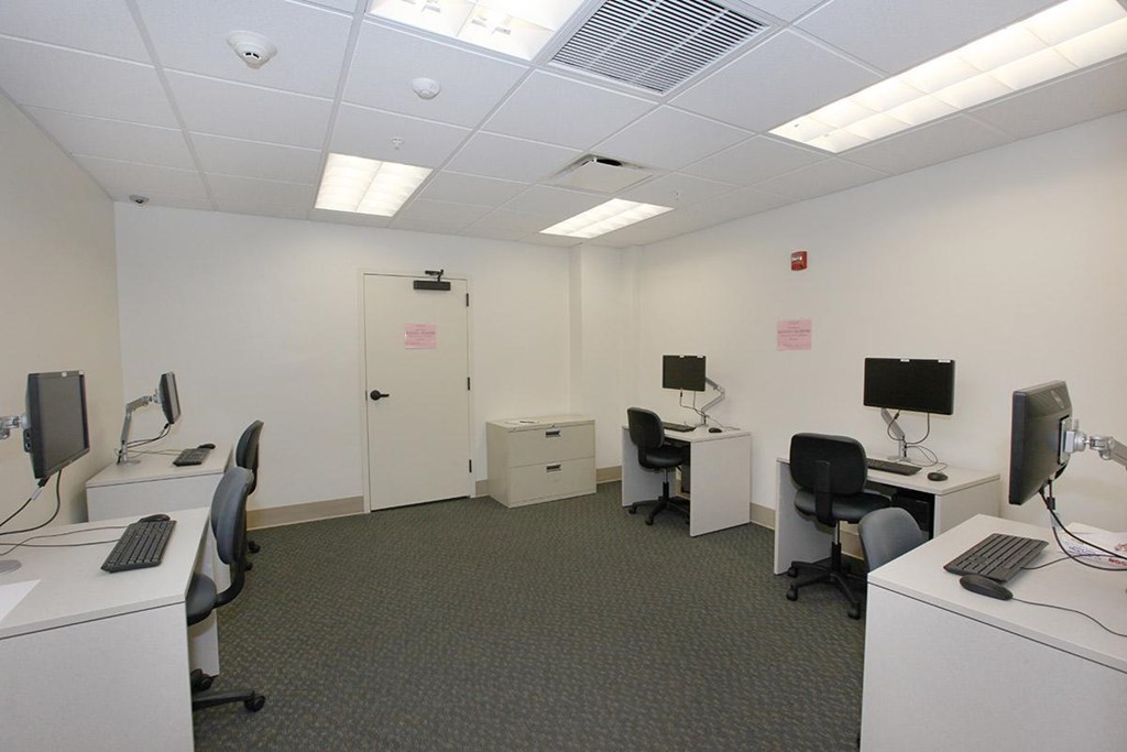 a classroom with desks and computers in a room