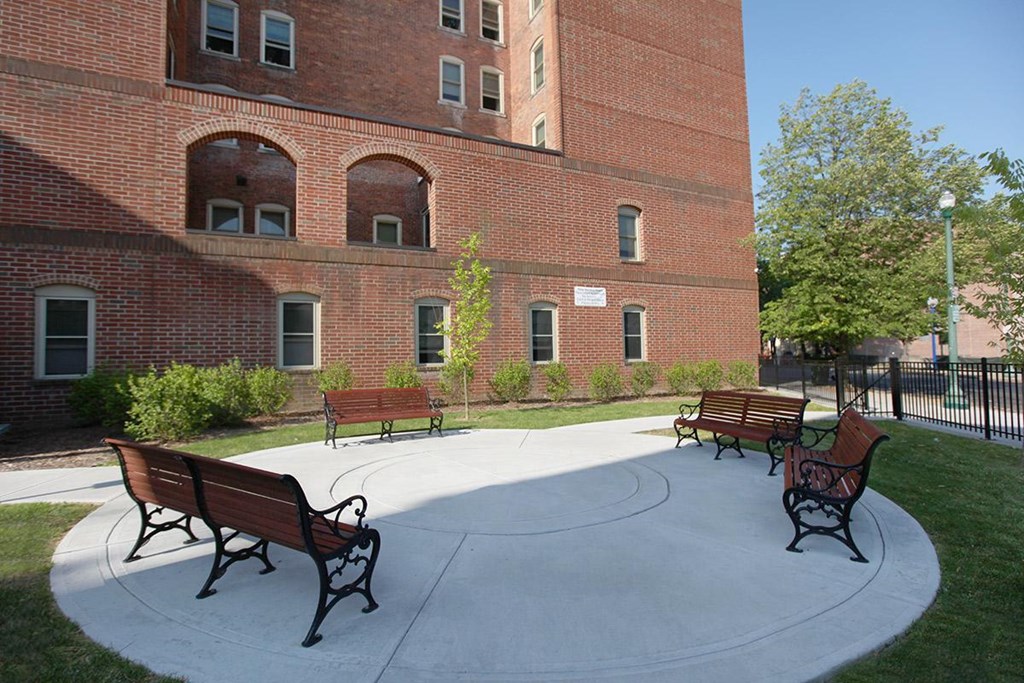 a group of benches in front of a brick building