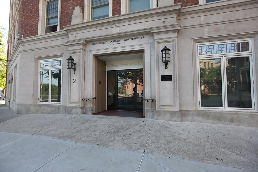 the front of a building with a door and a sidewalk