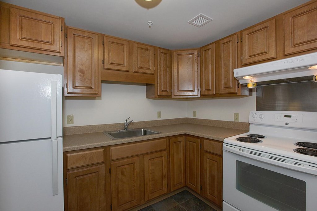 a kitchen with white appliances and wooden cabinets