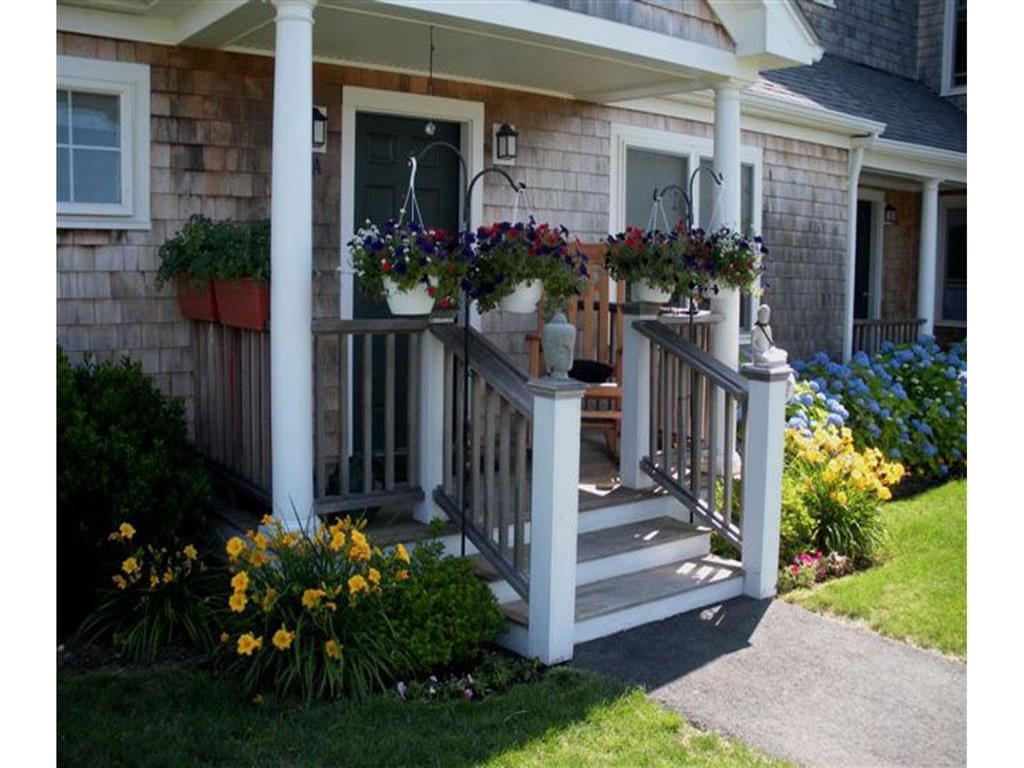 the front porch of a house with flowers on it