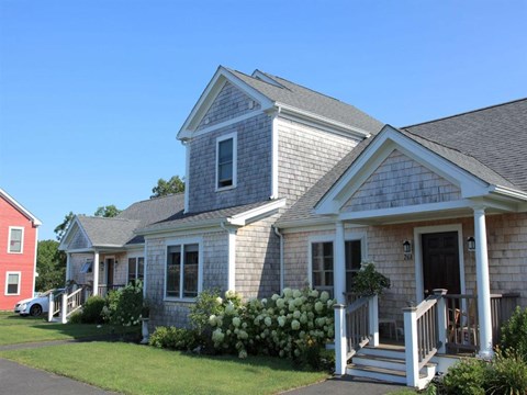 the front of a house with a porch and stairs